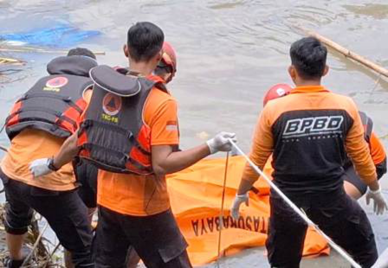 petugas BPBD Kota Surabaya saat melakukan evakuasi mayat wanita tenggelam di Sungai Jagir.