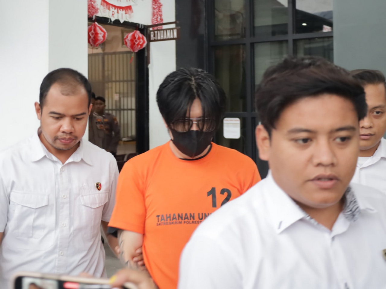 AAS berbaju tahanan diapit petugas Sat Reskrim Polrestabes Surabaya pasca ditangkap, 24 Agustus 2025.