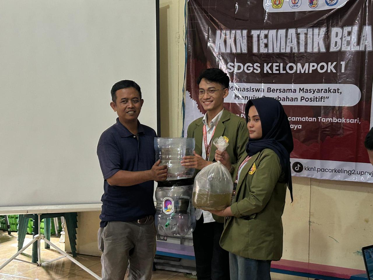 Penyerahan bibit ikan lele kepada warga Pacarkeling Surabaya oleh mahasiswa KKN Kelompok 1 UPN Veteran Jatim.