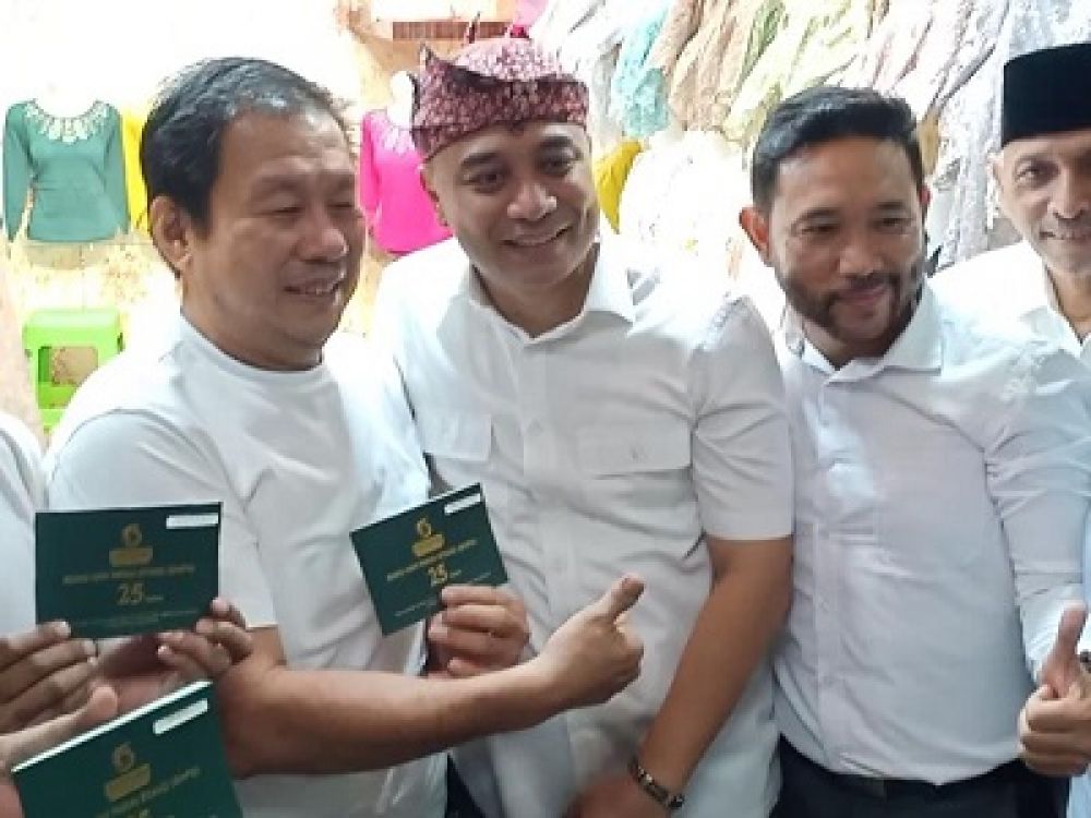 Wali Kota Surabaya Eri Cahyadi memberikan buku stand toko kepada pedagang Pasar Turi Baru yang menerima insentif kontrak 10 tahun.