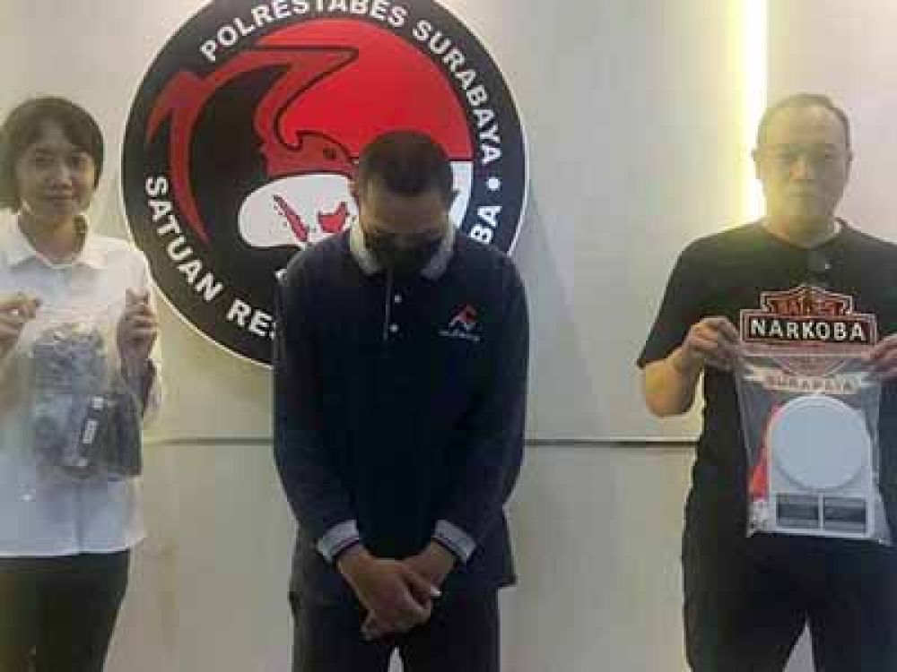 Tersangka NJA, kurir Ganja dan Sabu-sabu diapit dua petugas Sat Resnarkoba Polrestabes Surabaya.