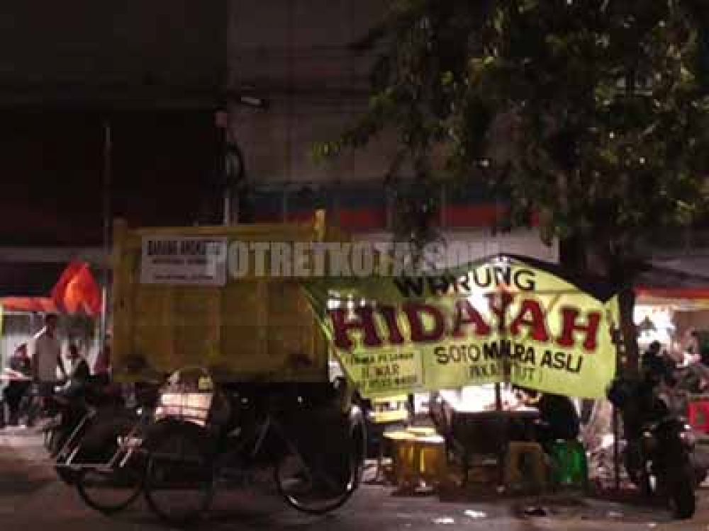Truk berplat nomor kuning S 7996 UP bertuliskan ‘Barang Angkutan Apoteker. Farmasi Wilayah Jatim’ pada bagian belakang bak truk, terparkir di sisi kiri depan Ruko yang akan digunakan untuk apotek Kimia Farma.