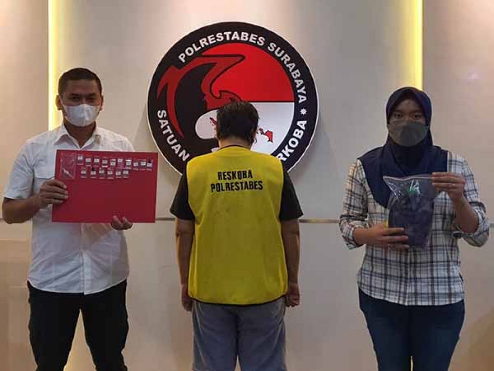 Tersangka KK diapit dua petugas Sat Resnarkoba Polrestabes Surabaya.
